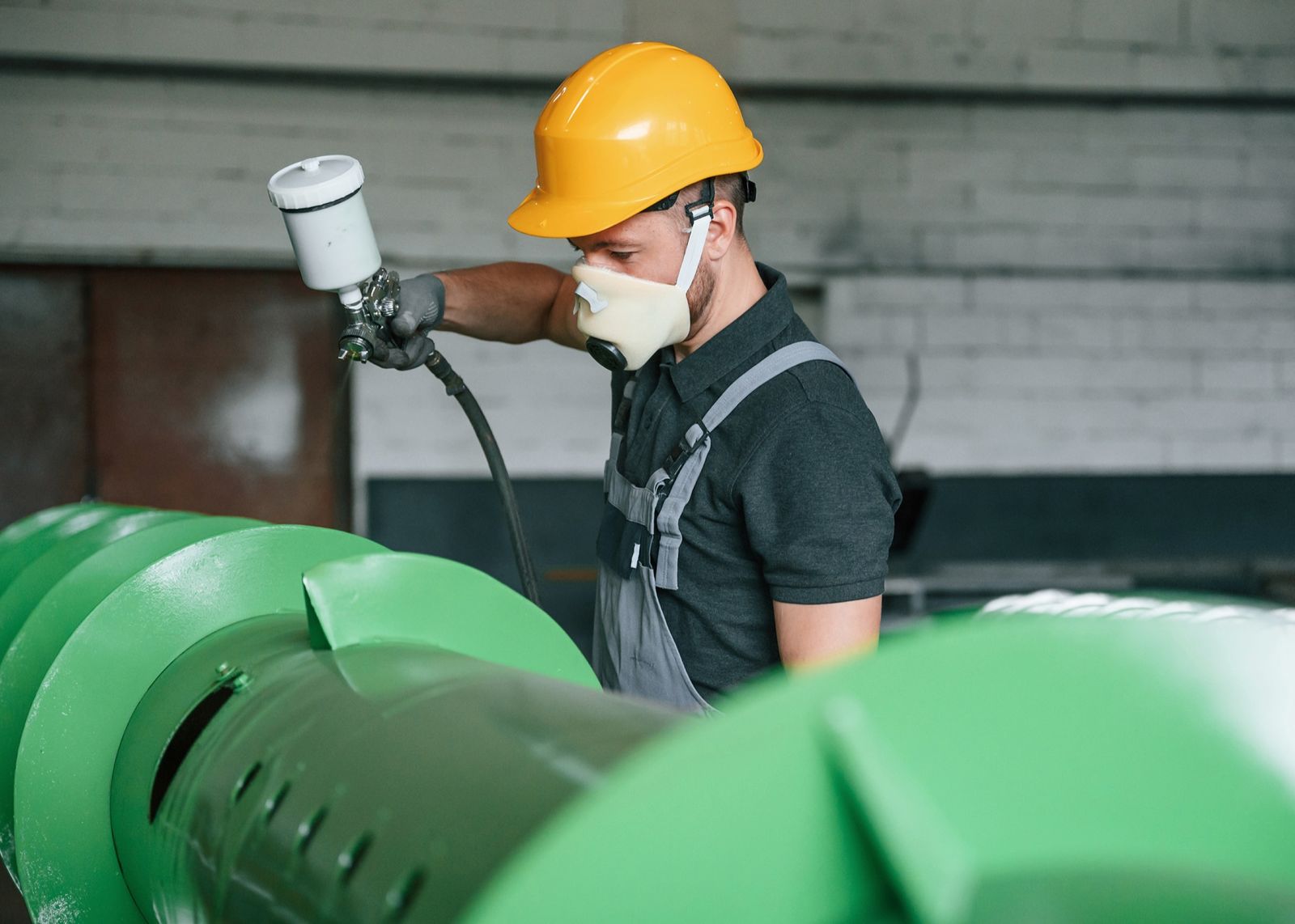 WIPCO technician spray-applying industrial coating